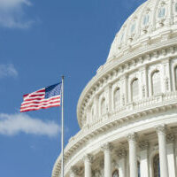 American flag waving in front of Capitol Hill